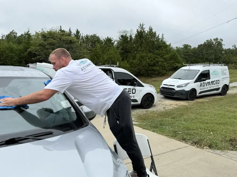 AMD tech cleaning a windshield in a parking lot in Louisville